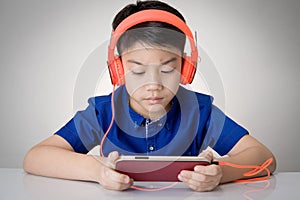 Asian boy ware headphone and playing the cell phone