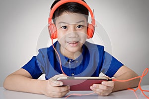 Asian boy ware headphone and playing the cell phone