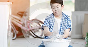 Asian boy washing his towel by hand.