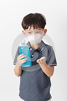 Asian boy wearing a protection maskâ€‹ and holding bottle of alcohol gel for cleaning baby hands to prevent against infection of