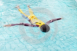 Asian boy wearing a swimsuit that floats in water. It is a practice of survival.