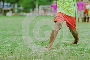 Asian boys practice kicking the ball to score goals