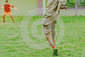 Asian boys practice kicking the ball to score goals