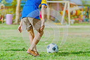 Asian boys practice kicking the ball to score goals