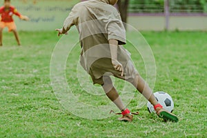 Asian boys practice kicking the ball to score goals