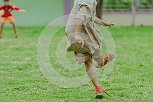 Asian boys practice kicking the ball to score goals