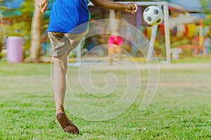 Asian boys practice kicking the ball to score goals