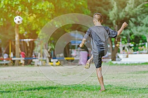 Asian boys practice kicking the ball to score goals