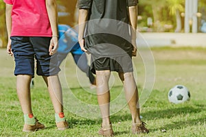 Asian boys practice kicking the ball to score goals