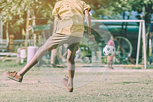 Asian boys practice kicking the ball to score goals