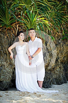 Asian bride and groom on a tropical beach. Wedding and honeymoo