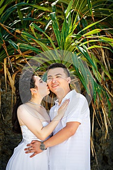 Asian bride and groom on a tropical beach. Wedding and honeymoo