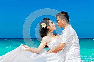 Asian bride and groom on a tropical beach. Wedding and honeymoon