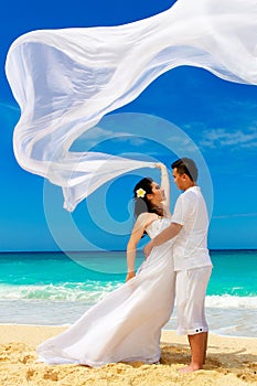 Asian bride and groom on a tropical beach. Wedding and honeymoon