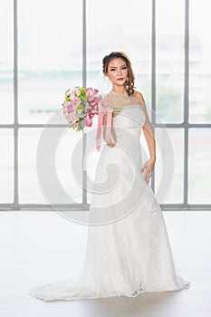 Asian bride standing and holding a bouquet