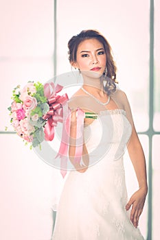 Asian bride standing and holding a bouquet