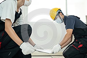 Asian builder worker people wear mask installs laminate board on floor. Construction team or Carpenter man and woman wear safety