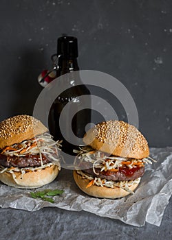 Asian burger with hoisin ketchup and chili mayo and beer on a gray background. Asian style