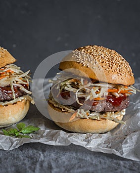 Asian burger with hoisin ketchup and chili mayo on a gray background. Asian style