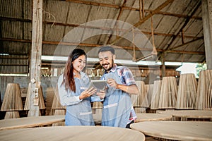 Asian business couple wearing aprons work on a tablet together