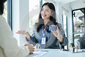 Asian business customer service representatives work serve sell credit card to customers. choosing insurance plan in office