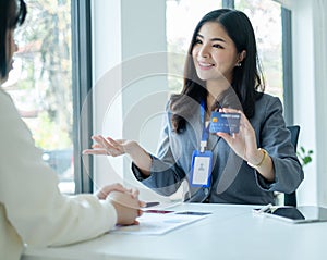 Asian business customer service representatives work and smile serve sell credit card to customers. choosing insurance plan in