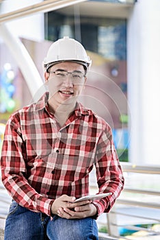 Asian business and engineer man with red scott shirt has planning and working for design buiding and city.