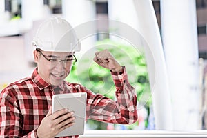 Asian business and engineer man with red scott shirt has planning and working for design buiding and city.