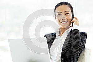 Asian business executive woman with laptop and smartphone
