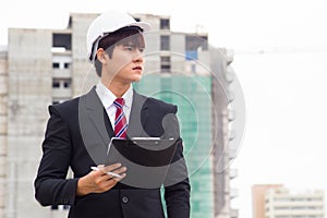 Asian business inspector holding clipboard checking material in construction site