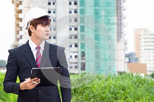 Asian business inspector holding clipboard and checking material in construction site
