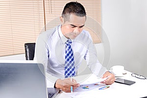 Asian business man looking at document in work place office