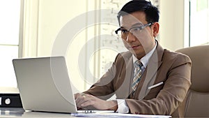 Asian Business man Looking Intense at the Sales Figures on the Computer