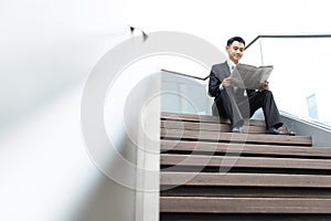 Asian Business man reading a newspaper