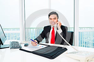 Asian business man telephoning in office