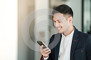 Asian business man using cell phone. Having Conversation, typing sms or presenting.