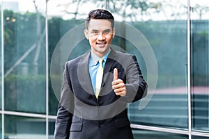 Asian business man walking in front of building
