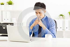 Asian business man watching laptop and thinking