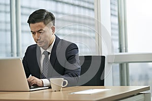 asian business man working in office using laptop computer