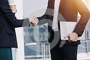 Asian business man and young beautiful woman working on digital tablet computer standing outside office building