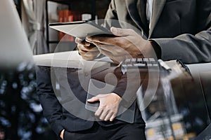 Asian business man and young beautiful woman working on digital tablet computer standing outside office building