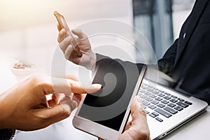 Asian business man and young beautiful woman working on digital tablet computer standing outside office building