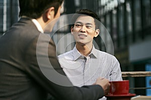Asian business men meeting in outdoor cafe