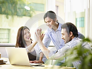 Asian business people celebrating success in office photo