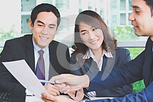 Asian business people discussing document in a meeting