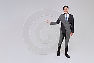 asian business people man good looking in studio. businessman in grey suit confident presenting or showing open hand palm