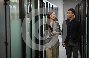 Asian business people man and woman walking and talking in office