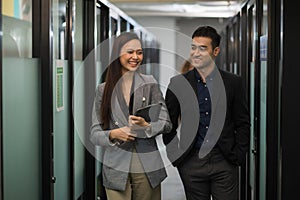 Asian business people man and woman walking and talking in office