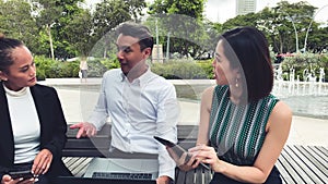 Asian business people meeting outdoor, talking and holding laptop, shaking hands