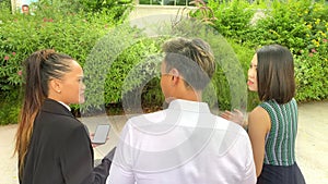 Asian business people meeting outdoor, talking and using laptop and smartphone, back view